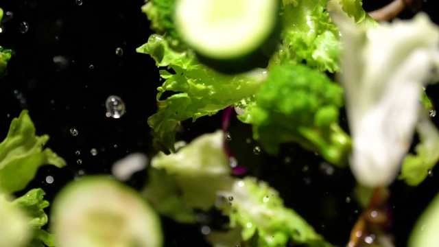 绿色沙拉飞溅到镜头的慢镜头视频素材