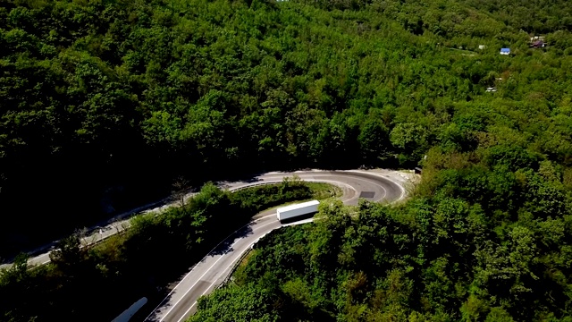 鸟瞰图的山路蜿蜒与汽车和卡车。视频素材