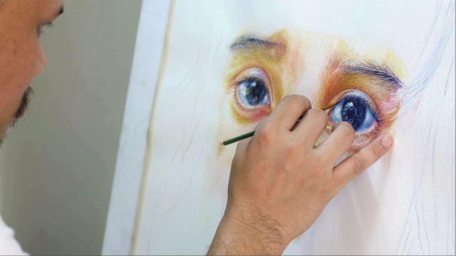 画家用水彩在白纸上画女孩子的肖像。视频下载