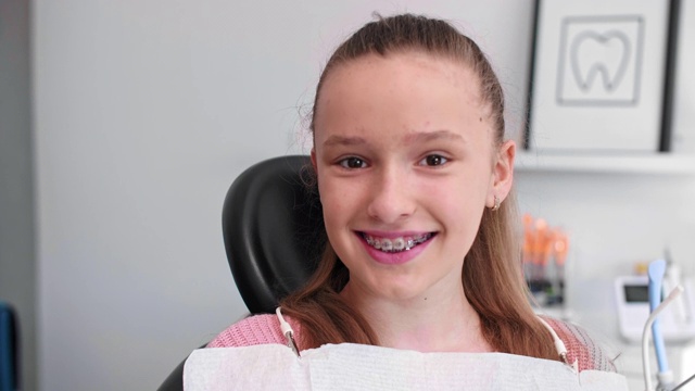 带着牙套微笑的少女在牙医办公室的肖像视频下载