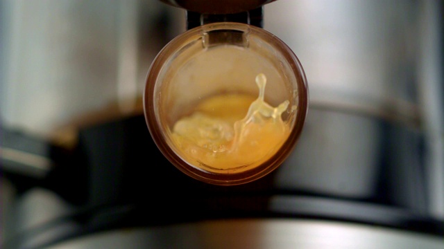橙汁从榨汁机中流出。超级慢动作视频素材