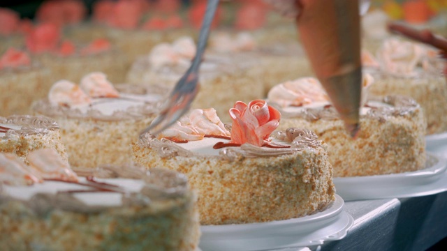 工人用玫瑰装饰蛋糕，特写。视频素材