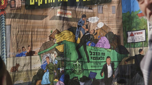 小朋友站在耶路撒冷街头的反以色列国防军卡通标志前视频下载