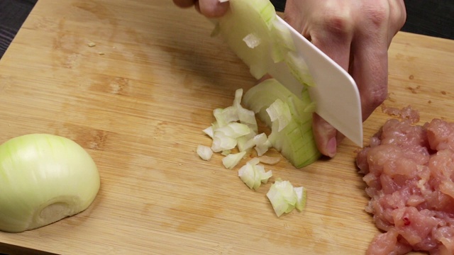 女厨师的手切洋葱片用于煎炸或沙拉。在自制食谱的烹饪过程中。视频素材
