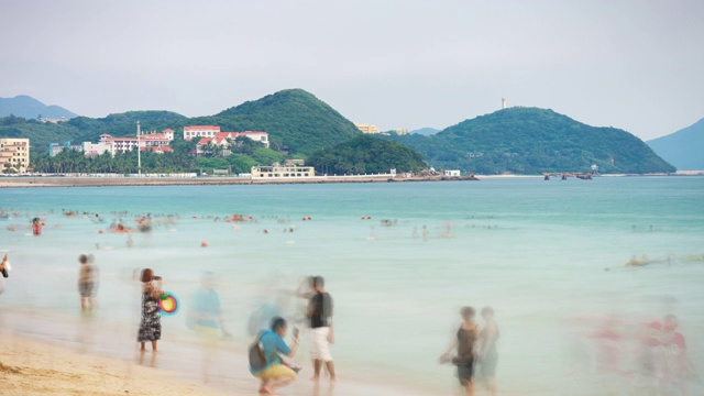 日落三亚著名的大东海拥挤的海滩全景4k时间推移海南岛中国视频素材