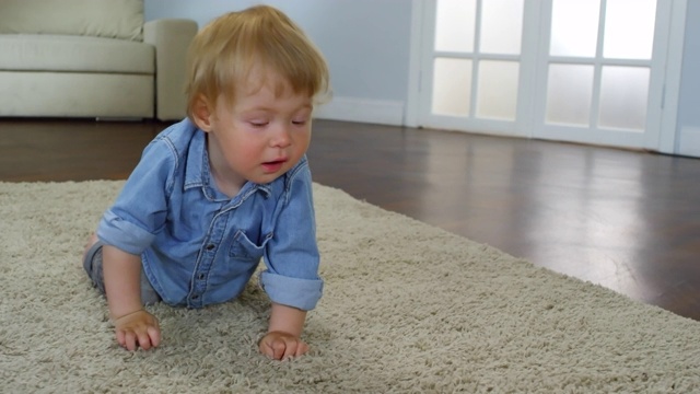 坚定的小男孩在地毯上爬行视频素材