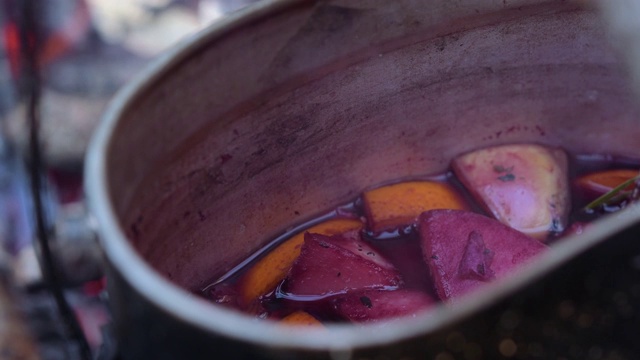 在营火上徒步旅行时，用锅盛着热红酒。视频素材