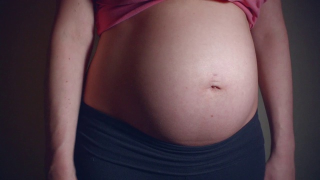近距离视频母亲摆动和摇晃她的怀孕的肚子视频素材