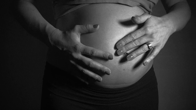 近距离视频母亲摆动和摇晃她的怀孕的肚子视频素材