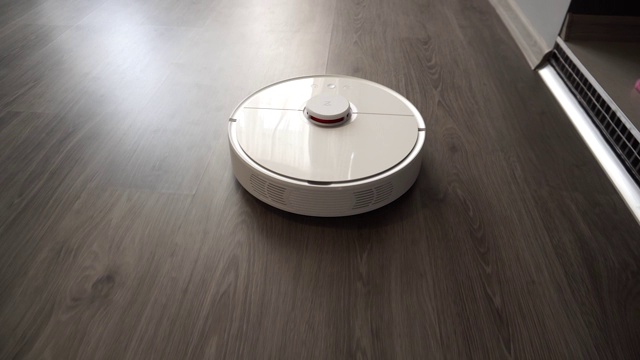 现代自主真空吸尘器在层压板上滑动视频素材