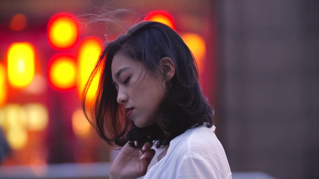 迷人的年轻亚洲女人在城市夜晚对着相机微笑视频素材