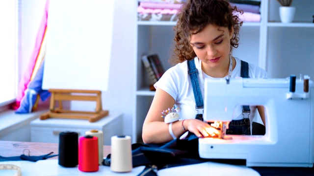 在工作室里用缝纫机工作的女裁缝视频素材