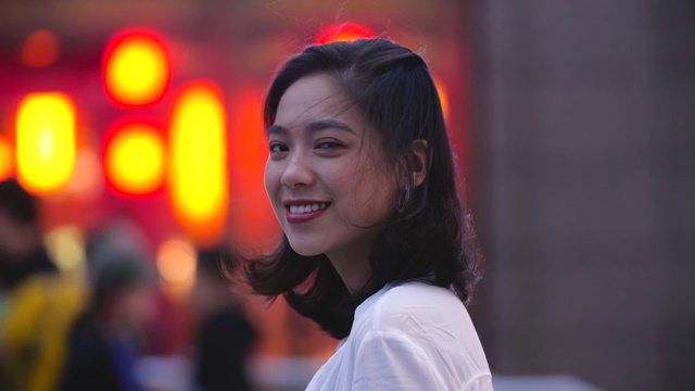 漂亮的亚洲年轻女子在晚上对着镜头微笑视频素材