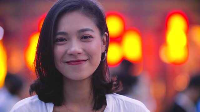 年轻亚洲女孩的肖像与城市背景微笑，4k视频素材