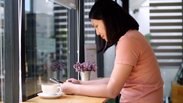 度假的生活方式，女人在咖啡馆用智能手机喝咖啡视频素材