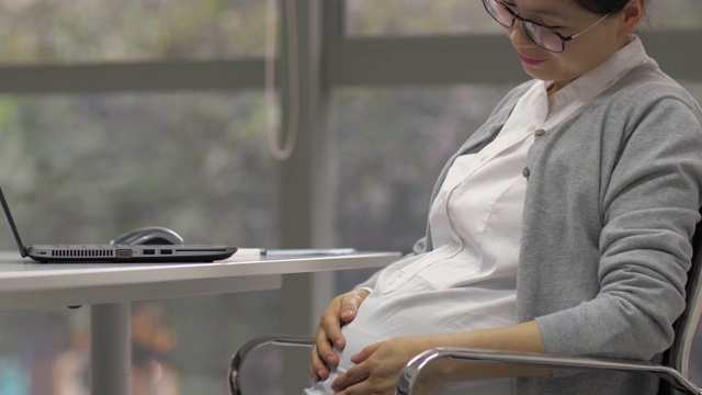 一名中国孕妇微笑着工作视频素材