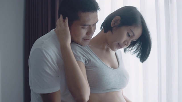 一对深情的怀孕夫妇在家里拥抱。视频素材