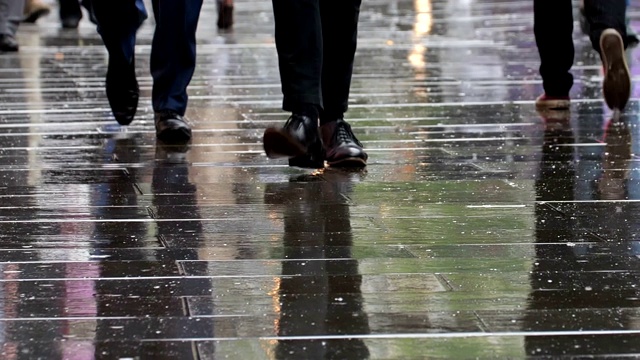 商人行走在雨中的城市。下身，腿和脚。视频素材