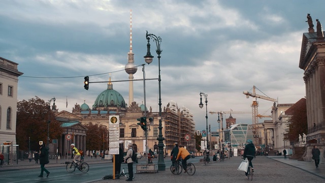 慢镜头，日落时首都大街上骑自行车的人。背景是柏林电视塔和大教堂。健康生活理念，环保理念视频素材