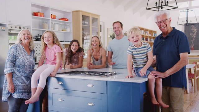 多代家庭一起站在厨房岛周围的肖像视频素材