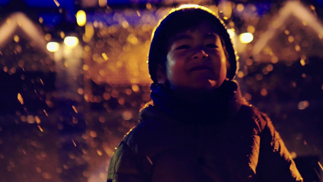 快乐的亚洲孩子晚上在雪中玩耍。视频下载