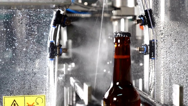 啤酒厂的空瓶子正在经过工艺洗涤线。啤酒厂啤酒装瓶工艺线。4 k视频素材