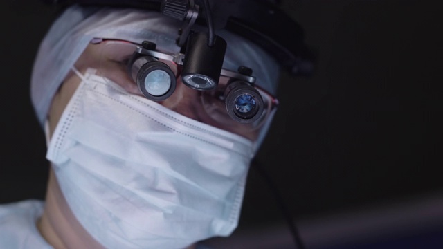 医生用手术放大镜看着摄像机视频下载