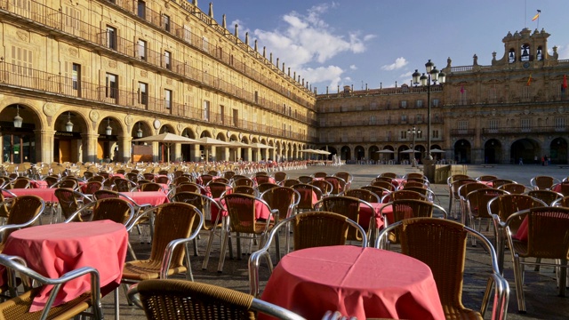 在西班牙萨拉曼卡市市长广场的咖啡馆里漫步，那里摆着粉红色的桌子和柳条椅。萨拉曼卡是该国西部的一个城市，位于卡斯提尔和莱昂社区视频下载