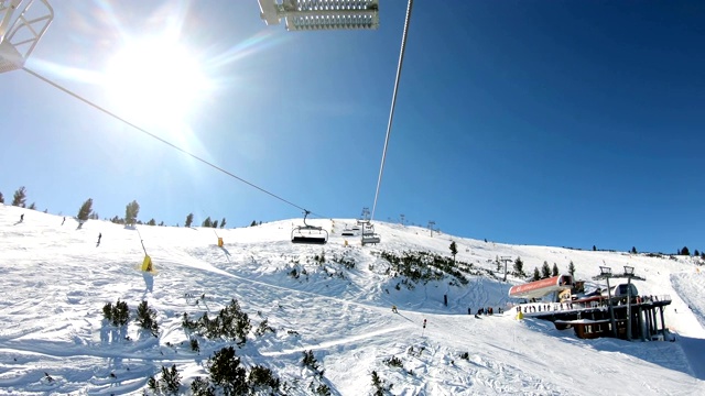 在保加利亚班斯科，滑雪者正乘坐滑雪缆车前往山顶的一个滑雪场。班斯科是世界杯冬季滑雪胜地视频素材