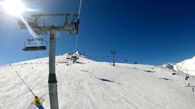 在一个阳光明媚的日子里，在一个滑雪胜地乘缆车登上山顶视频素材