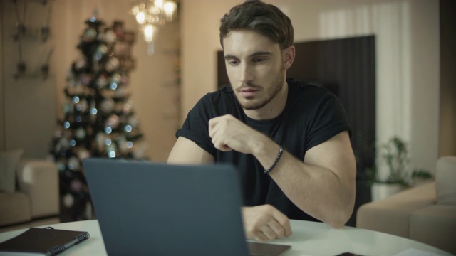 男人程序员工作笔记本电脑在新年的家。文案阅读网站视频下载