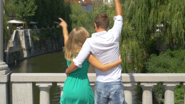 慢镜头:一对相爱的年轻游客走过卢布尔雅那的一座桥。视频下载
