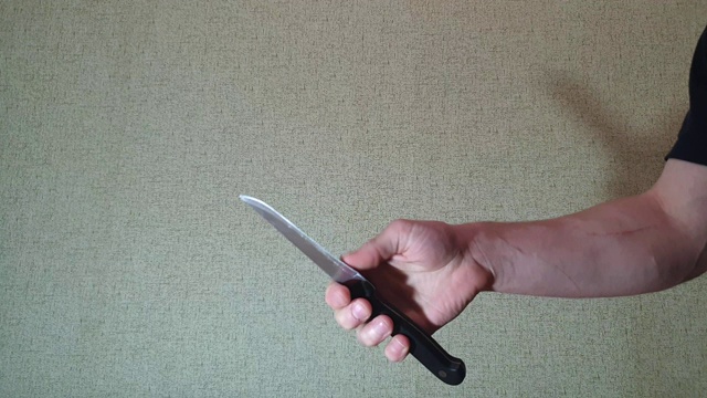 那人正在用慢镜头转动手中的一把刀。他手里拿着刀。视频下载