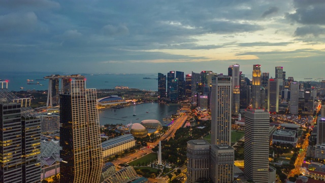 日落时间照明新加坡城市滨海湾市中心空中全景，4k时间间隔视频下载