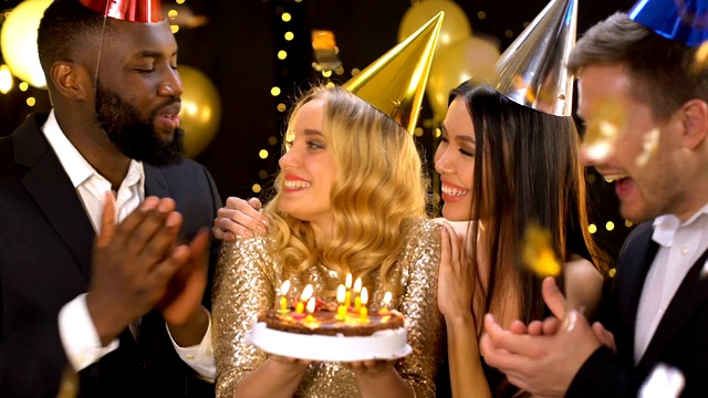 快乐的女性和密友一起享受生日，吹灭蛋糕蜡烛视频素材