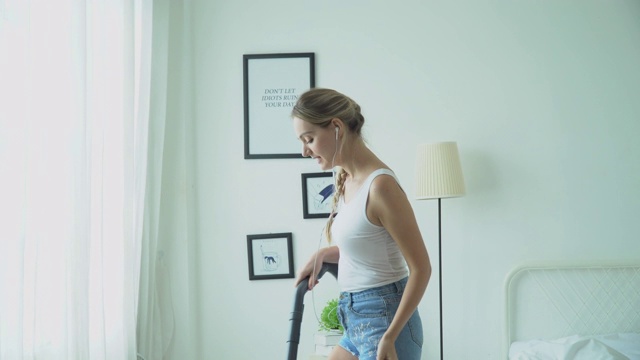 快乐的家庭主妇用吸尘器打扫房间视频素材