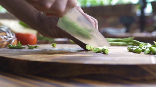 刀把青豆切成薄片。慢镜头厨师在厨房切青豆。地中海菜的蔬菜配料。素食、健身菜单和健康食品视频下载