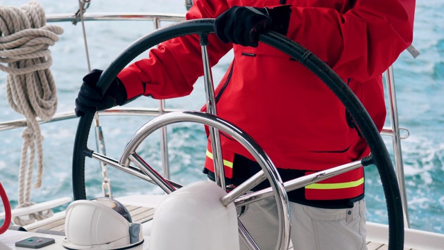 游艇由一名身穿红色皮大衣的专家控制视频下载