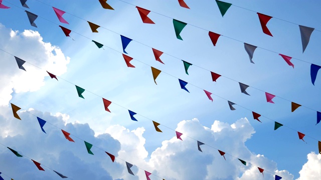 4 k。五彩缤纷的设计装饰三角旗迎风飘扬，蓝天为背景，为欢乐节日派对活动、节日盛宴庆祝活动、狂欢节节庆活动等。视频下载