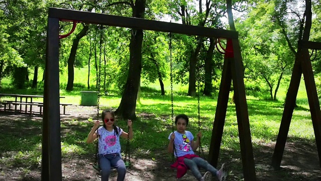 快乐的女孩在公园荡秋千，慢镜头视频素材