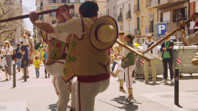 加泰罗尼亚传统舞蹈表演团体的年轻人。在巴塞罗那的格雷西亚区街道上，人们互相跳跃，撞到对方的电线杆视频素材