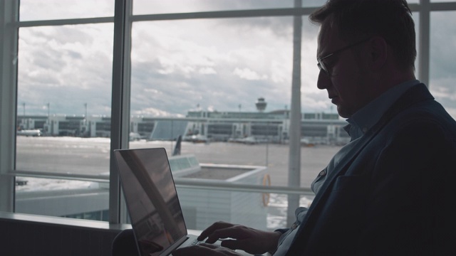 深思熟虑的商人在机场使用笔记本电脑视频素材