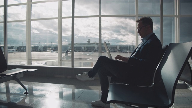 在机场候机时使用笔记本电脑的企业家视频素材