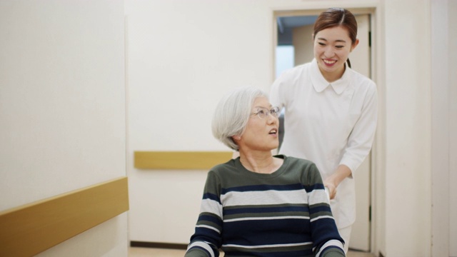 护士用轮椅推病人走过医院走廊视频下载