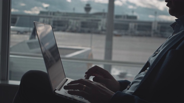 在机场等候时使用笔记本电脑的商人视频素材