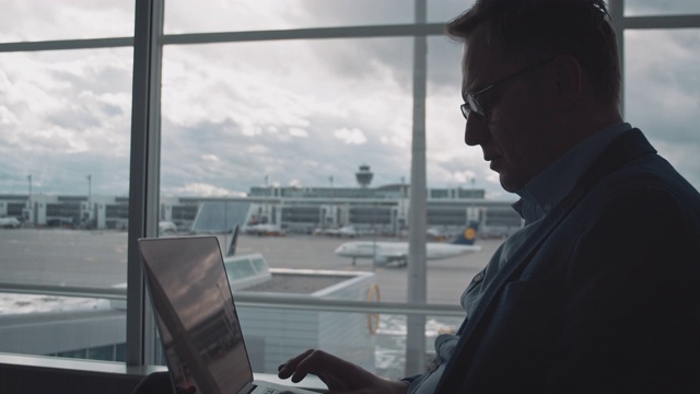 男性企业家在机场使用笔记本电脑视频素材