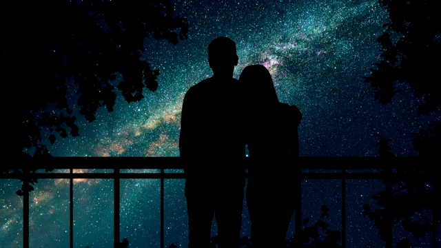 这对情侣站在树旁，映衬着繁星点点的天空。时间流逝视频素材