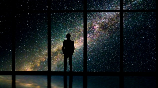 在布满星星的天空背景下，站在窗边的那个人。时间流逝视频素材