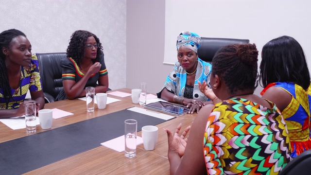 谦卑的非洲女商人倾听她的员工在一个小组会议视频下载