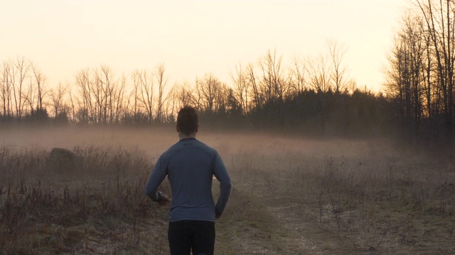 成年男性跑步者在日落时在乡间跑步视频素材